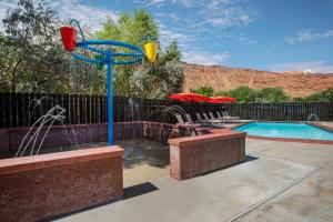 a pool with a water fountain in a yard at Sun Outdoors Moab Downtown in Moab