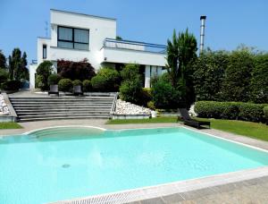 a swimming pool in front of a house at Arosio Hotel in Arosio