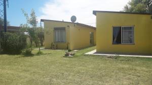 a yellow house with a yard next to it at Departamento Teodelina in Quehué