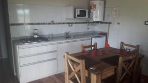 a kitchen with a table and a sink and a stove at Departamento Teodelina in Quehué