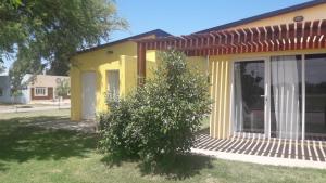 a yellow house with a tree in front of it at Departamento Teodelina in Quehué