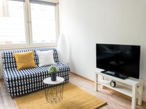 a living room with a couch and a flat screen tv at Moderne Innenstadt Whg mit Netflix und Nespresso in Mannheim