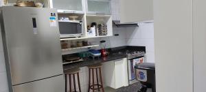 una pequeña cocina con nevera y microondas en Apartamento Familiar 3 quartos - Leblon en Río de Janeiro