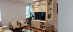sala de estar con TV, sofá y sillas en Apartamento Familiar 3 quartos - Leblon, en Río de Janeiro
