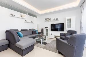 a living room with two couches and a flat screen tv at Fortuna -7/1 in Rojales