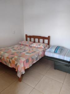 una cama y un banco en una habitación en Beautiful day suítes, en Ilhabela