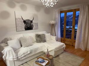 a living room with a white couch and a bull on the wall at Verbier One Chalet in Verbier