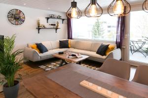 a living room with a couch and a table at Spirit Apartments - Balkon - Bergsicht - Parkplatz in Engelberg