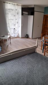 a bedroom with a bed in a room with a curtain at Aux doux refuges de la muse Studio in Montjaux
