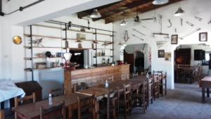 una sala da pranzo con tavoli e sedie in legno di Posada de campo LA AMADA a San Pedro