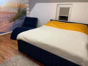 1 cama y 1 silla en un dormitorio con vistas a la playa en Apartament przy ulicy Zaruskiego blisko plaży, en Ustka