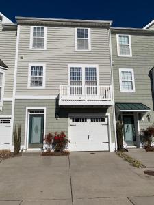 a large house with two garage doors and a balcony at 37100 turnstone circle in Rehoboth Beach