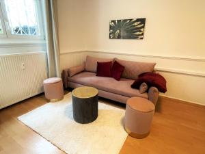 un soggiorno con divano e 2 sgabelli di UrbanSuites - Dein Zuhause in Wiesbaden a Wiesbaden