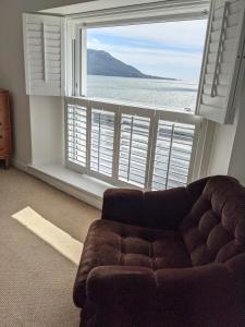 a living room with a couch and a large window at 'A room with seaview' on Carlingford Lough in Warrenpoint