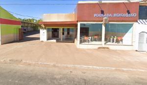 an empty parking lot in front of a restaurant at Hotel Kolosso in Aragarças
