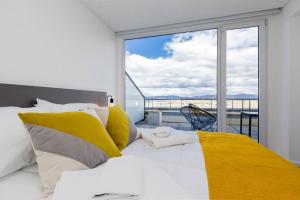a bedroom with a bed and a large window at Pacifico Departamentos in Ushuaia