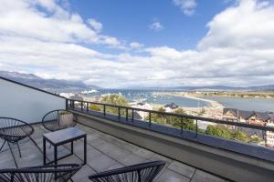 a balcony with chairs and a view of the water at Pacifico Departamentos in Ushuaia