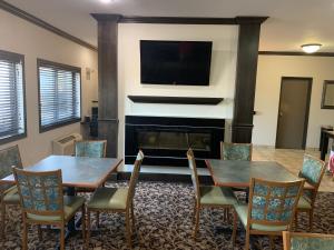 a living room with two tables and a fireplace at Quality Inn near I-72 and Hwy 51 in Forsyth