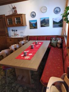 una sala da pranzo con tavolo in legno e tappeto rosso di Bio-Bauernhof Schiederhof a Fusch an der Glocknerstrasse