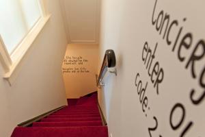 ein Treppenhaus mit roter Treppe mit Schreiben an der Wand in der Unterkunft Amsterdam Rembrandt Square city center Hotel in Amsterdam