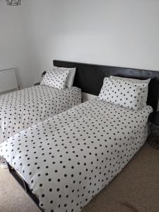 two beds with black and white sheets and pillows at 'A room with seaview' on Carlingford Lough in Warrenpoint