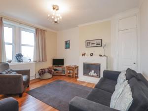 a living room with a couch and a fireplace at 13 Sconser in Sconser