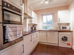 a kitchen with white appliances and a window at 13 Sconser in Sconser