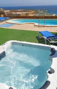 a large swimming pool with a large blue pool at Luxury 5 star Villa Violetta with amazing sea view, jacuzzi and heated pool in San Agustin