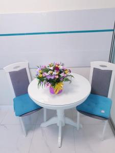 uma mesa branca com um ramo de flores em Апартаменти завжди зі світлом em Dnipro