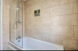 スウォンジーにある4 Bed House - Sleeps 11 - Pets - Parking - Wifiの白い浴槽とシャワー付きのバスルーム