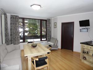 uma sala de estar com uma mesa e um sofá em Deer's Home at Elit Pamporovo em Pamporovo