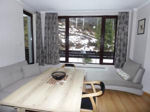 ein Wohnzimmer mit Tisch und Couch in der Unterkunft Deer's Home at Elit Pamporovo in Pamporowo