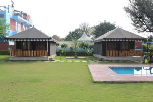 um pavilhão com piscina num quintal ao lado de um edifício em Amrit Van Resort em Jaipur