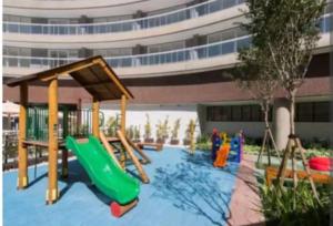 a playground with a slide in front of a building at Santos Unlimited 2 Dormitórios, 32o andar com vista Mar! in Santos