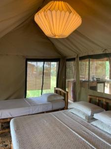 a bedroom with two beds in a tent at Natura Luxury Lake Hut in Ouidah