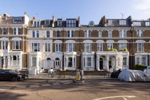 ein großes Gebäude mit weißen Türen und Fenstern in der Unterkunft Luxurious 1-Bedroom Apartment in Kensington in London