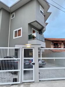 a house with a white gate in front of it at Apartamento Completo Próximo a Praia - Residencial Vieira in Florianópolis