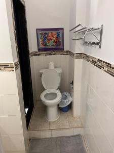 a bathroom with a toilet with a painting on the wall at Adas Guesthouse in Toronto
