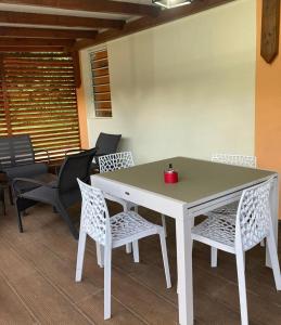 una mesa blanca con sillas y una vela roja. en VILLA TIBOU en Petit-Bourg