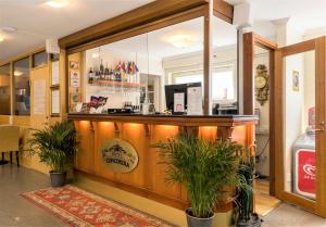 a bar in a restaurant with two potted plants at Hotel Concordia in Lund