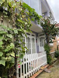 a white picket fence in front of a house with a white gate at Evangeline House in Da Lat