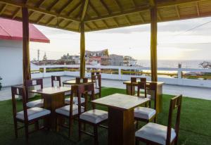 un restaurante con mesas y sillas en un balcón en Hotel Sol y Playa Montañita, en Montañita