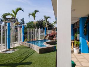 a pool in a yard with a fence and palm trees at Hotel Sol y Playa Montañita in Montañita