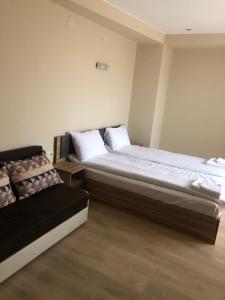 オグニャノヴォにあるСтаи за гости Праматарови Огняновоのベッド2台とソファのある寝室 +19枚の写真