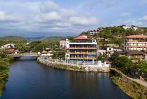 einen Fluss mit Gebäuden und einer Brücke in einer Stadt in der Unterkunft Hotel Sol y Playa Montañita in Montañita