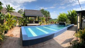 a swimming pool in front of a house at Dangau Sala D'Kontena in Alor Setar