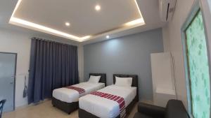 a bedroom with two beds and a projection screen at New blessing Home นิวเบลสซิ่ง โฮม in Nan