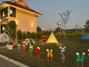 a garden with wooden figures of chickens and a tent at แดยอน โฮม(Daeyeon Home) in Nan