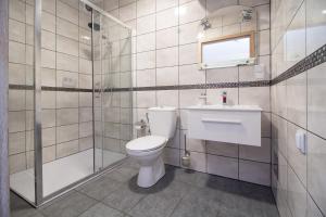 a bathroom with a toilet and a shower and a sink at OW Wilk - pokoje i domki z aneksami kuchennymi, parking, plac zabaw in Łeba +79 photos