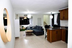 a living room and a kitchen with a couch and a table at El más completo, a menos de 5 minutos de la playa, free wifi fuera del alojamiento in San Felipe de Puerto Plata